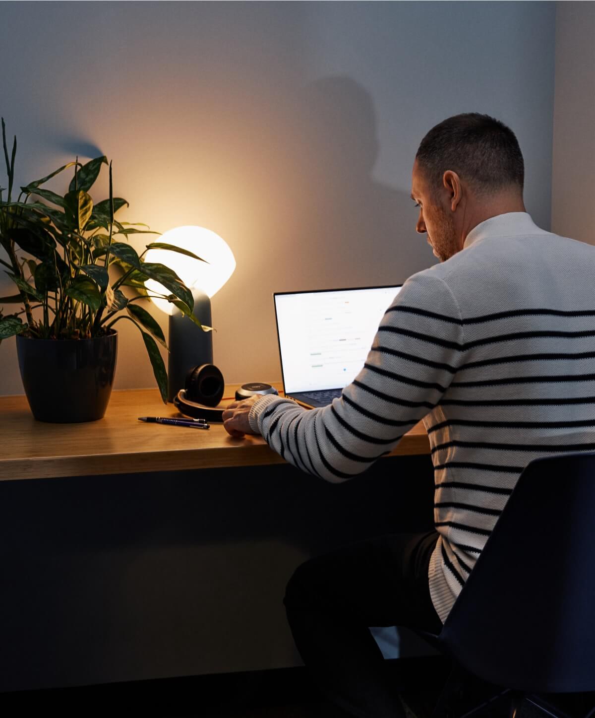 Un développeur de logiciels concentré travaillant à domicile, profondément absorbé par le codage, incarnant le dévouement et la passion dans son travail.